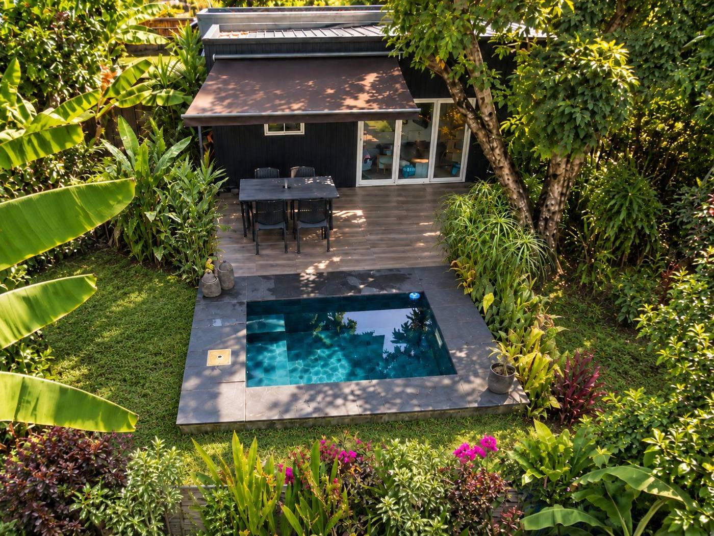 Tiny 1 vue du ciel : terrasse sous store, piscine et jardin tropical